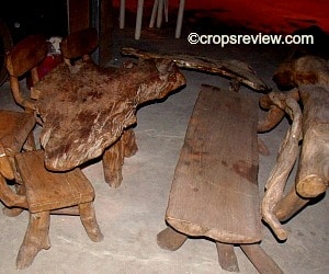 A furniture set consisting of a table, bench and seats. Driftwoods and crooked branches are used.